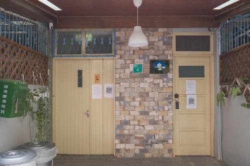 a hallway with two doors and a brick wall at South Gate Home Stay in Tainan