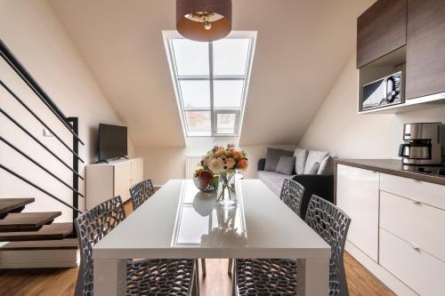 a kitchen and dining room with a white table and chairs at Prague Tales Boutique Residence by Dwellfort in Prague