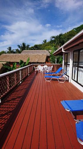 a deck with chairs and tables on a house at Muri Motu Outlook in Rarotonga