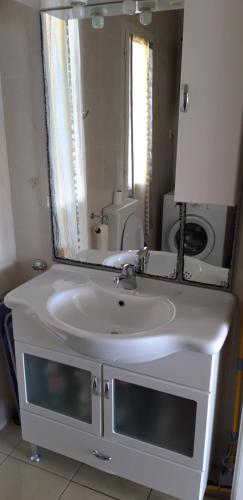 a bathroom with a white sink and a mirror at Sea house in Bibinje