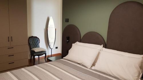 um quarto com uma cama grande e uma cadeira em Casa Marì em Garda
