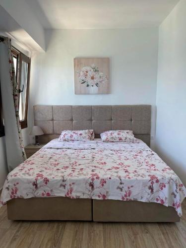 sypialnia z dużym łóżkiem z różowymi kwiatami w obiekcie Maria's room w mieście Samos