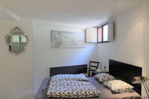 sypialnia z łóżkiem, krzesłem i lustrem w obiekcie La casa di Arnaldo La cuccia w mieście Agno