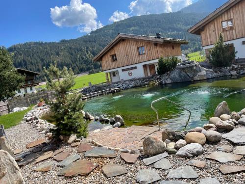a pool of water in front of a house at Sieglhub Chalets - Appartements - Hotel in Flachau