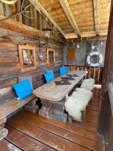 a wooden dining room with a table and blue chairs at Sieglhub Chalets - Appartements - Hotel in Flachau