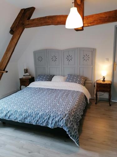 une chambre avec un grand lit avec une couette bleue dans l'établissement LOLA, à Montigny-sur-Crécy