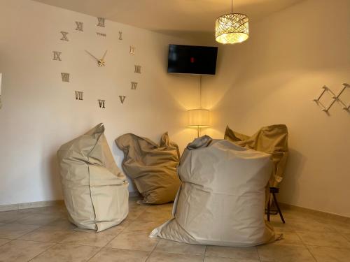 een kamer met drie witte stoelen en een klok aan de muur bij Lucky’s house in Noicattaro