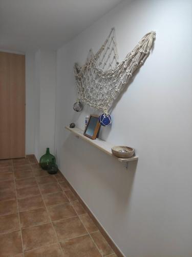 a shelf with a fish on a wall at O'Eirado Playa de Quenxe in Corcubión