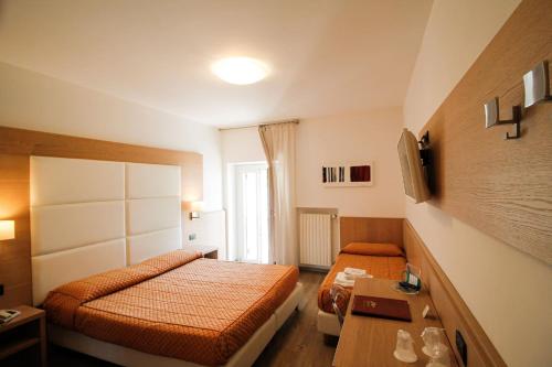 a small bedroom with two beds and a table at Hotel Europa in Desenzano del Garda