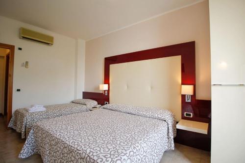 a bedroom with two beds and a large mirror at Hotel Europa in Desenzano del Garda