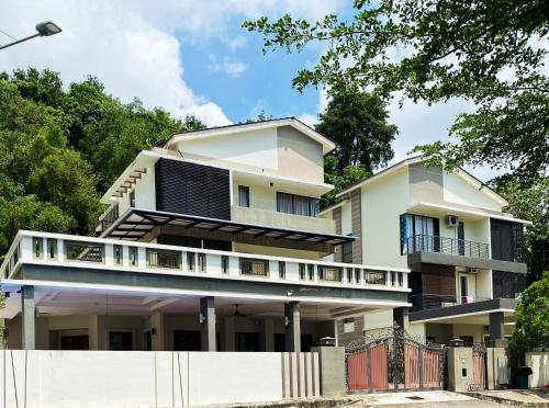 a white house with a balcony and a fence at Villa near SPICE Arena 3BR 15PAX with KTV Pool Table and Kids Swimming Pool in Bayan Lepas