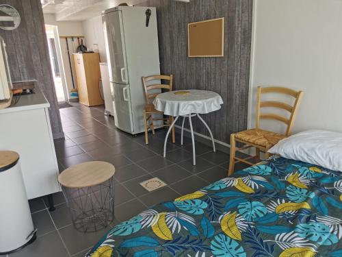 Habitación con cama, mesa y nevera. en Studio indépendant à BOURGNEUF-EN-RETZ vue sur les Marais à 5 mn des plages, en Bourgneuf-en-Retz
