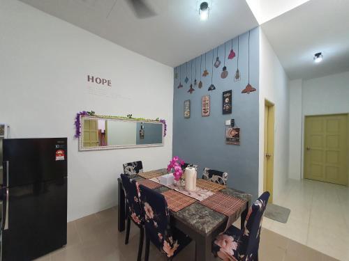 a dining room with a table and chairs and a refrigerator at Licuala Homestay Bukit Keluang in Kampung Raja