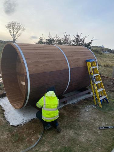 a man is working on a large wooden boat at Carters Rest Guesthouse in Milovaig