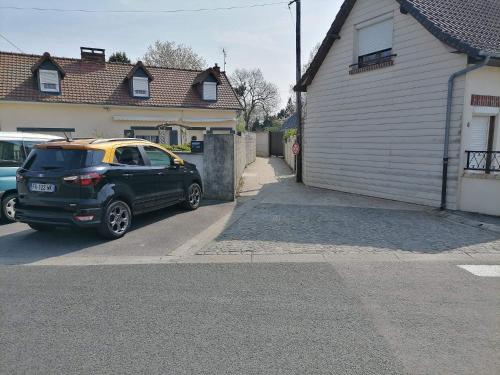 uma SUV preta estacionada em frente a uma garagem em Le pied à terre em Feuquières-en-Vimeu