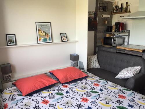 - un lit avec 2 oreillers rouges dans l'établissement LE ROC, à Granville