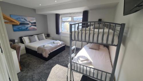 a bedroom with two bunk beds and a bed at Y Gwynedd Inn in Llanberis