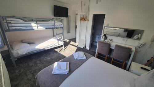a room with two bunk beds and a table and chairs at Y Gwynedd Inn in Llanberis