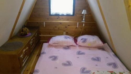 a tiny house with two pillows on a bed at Domek letniskowy 36 in Giżycko