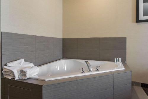 ein Badezimmer mit einer Badewanne und Handtüchern darauf in der Unterkunft Comfort Inn & Suites in Fox Creek