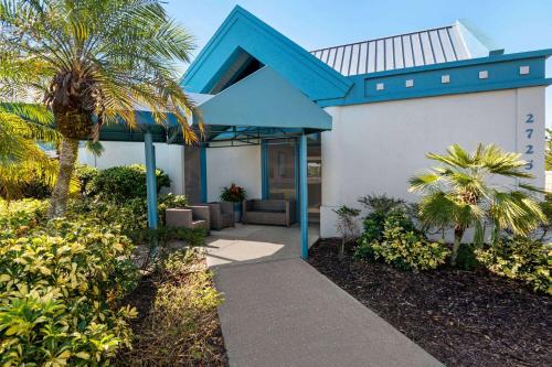 uma casa com um telhado azul e uma palmeira em Baymont by Wyndham Daytona Beach - Intl Speedway em Daytona Beach