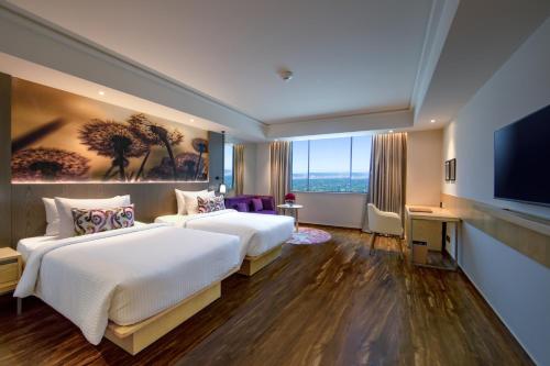 a hotel room with two beds and a flat screen tv at The Gaurs Sarovar Premiere in Ghaziabad