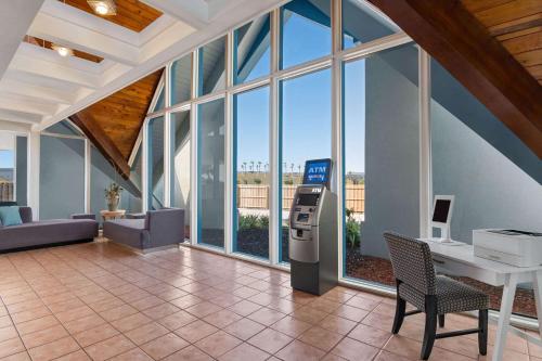 a large room with a desk and a table and windows at Baymont by Wyndham Intl Speedway I-95 Daytona Beach in Daytona Beach