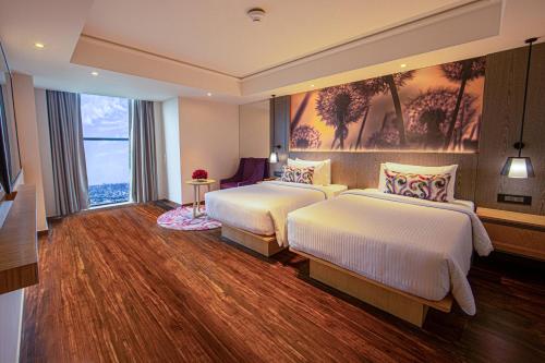 a hotel room with two beds and a large window at The Gaurs Sarovar Premiere in Ghaziabad