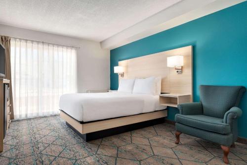 a hotel room with a bed and a chair at Ramada by Wyndham Miramichi New Brunswick in Miramichi