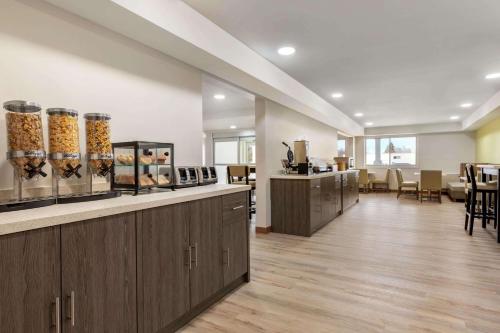 un salon avec une salle d'attente dotée de tables et de chaises dans l'établissement Ramada by Wyndham Miramichi New Brunswick, à Miramichi