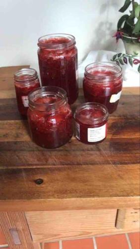 four jars of jam sitting on top of a wooden table at An Bothán-Cosy Cottage in the Cooley Mountains in Dundalk