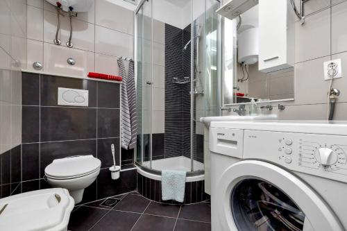 ein Badezimmer mit einem WC und einer Waschmaschine in der Unterkunft Apartman Goranka in Makarska