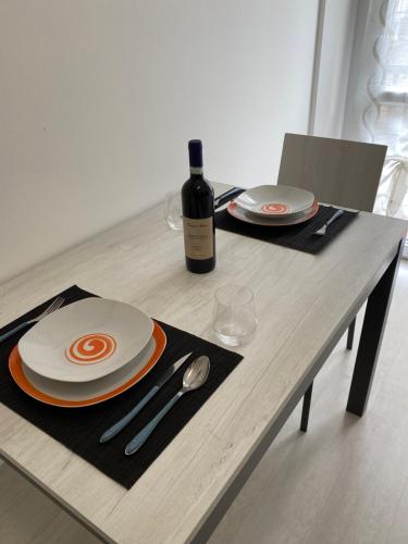 een tafel met een fles wijn en een bord en lepel bij First Home Milan in Milaan