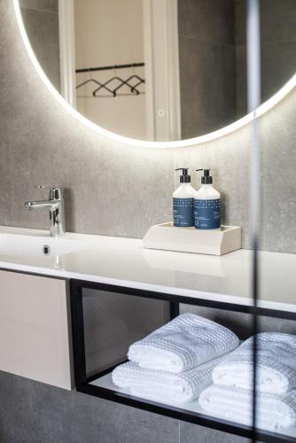 a bathroom with a sink and a mirror and towels at Baenk designhideaway in Nieuwpoort