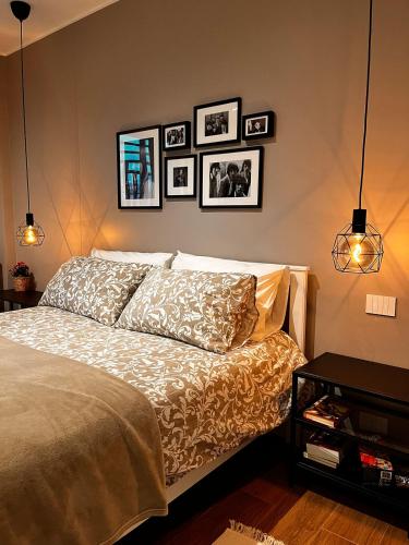 a bedroom with a bed with pictures on the wall at DeGasperi Studio Apartment in Trani