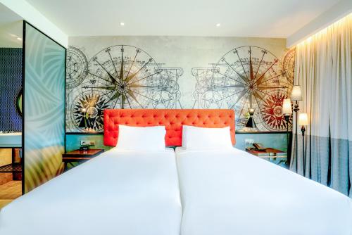 a bedroom with a large bed with a red headboard at Mercure Langkawi Pantai Cenang in Pantai Cenang