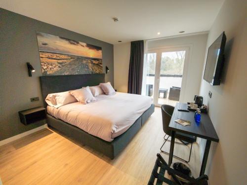 a bedroom with a bed and a desk with a television at El Cielo de Muriel mejor Hotel Starlight del mundo Astroturismo y Naturaleza in Muriel Viejo