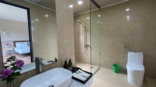 a bathroom with a sink and a shower and a toilet at PHOENIX MINH CHÂU HOTEL in Quang Ninh