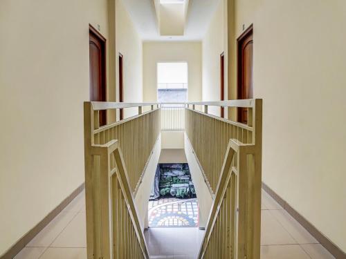 um corredor com uma escada numa casa em OYO 91084 Oke Guest House em Malang