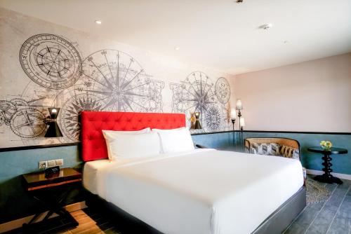 a bedroom with a large white bed with a red headboard at Mercure Langkawi Pantai Cenang in Pantai Cenang