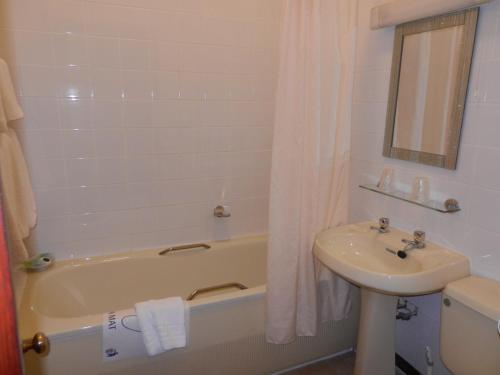a bathroom with a sink and a bath tub and a sink at Morangie Hotel Tain in Tain