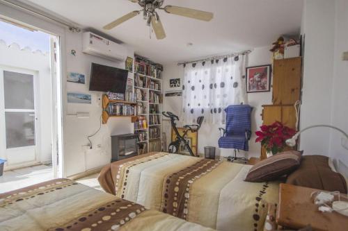 Apartamento a 300m de la playa en Roquetas de Mar في روكويتاس دي مار: غرفة نوم بسريرين ومروحة سقف