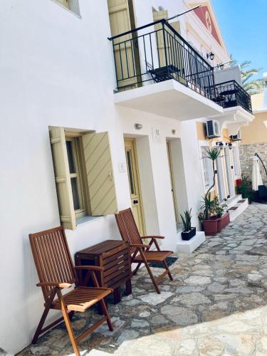 two chairs and a table on the side of a building at Aegli Apartments in Symi