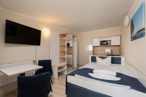 a bedroom with a bed and a desk and a computer at Aparthotel Stralsund Studios und Apartments in Stralsund