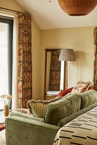 a living room with two green couches and a window at Rothay Manor Hotel in Ambleside