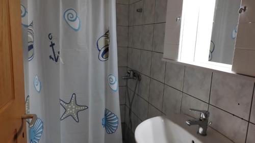 a bathroom with a shower curtain and a sink at Manto House - Alexandra Apartment in Káto Figália