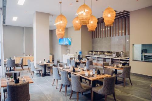 un restaurant avec des tables et des chaises et une cuisine dans l'établissement Polana Plaza Hotel, à Maputo