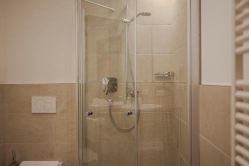a shower with a glass door and a toilet at Hotel Theresia in San Leonardo in Passiria