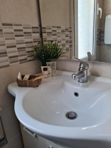 a white sink in a bathroom with a mirror at Hotel Marconi Miramare in Rimini