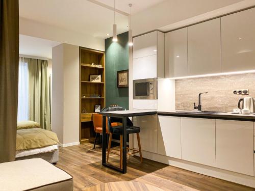 a kitchen with white cabinets and a table with chairs at Golden Horn Apart Hotel in Baku